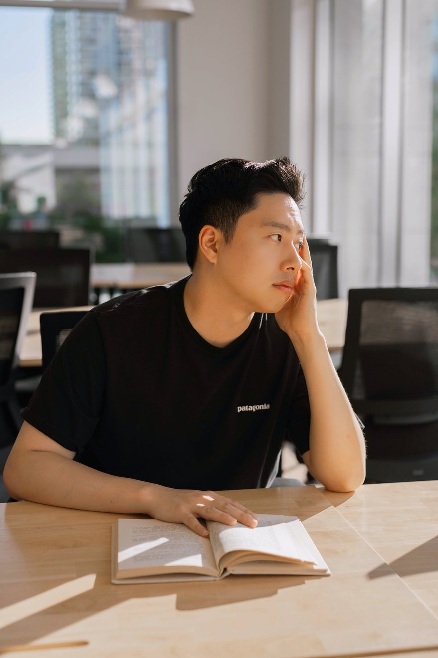 Dan Jeong staring out a window, pretending to think